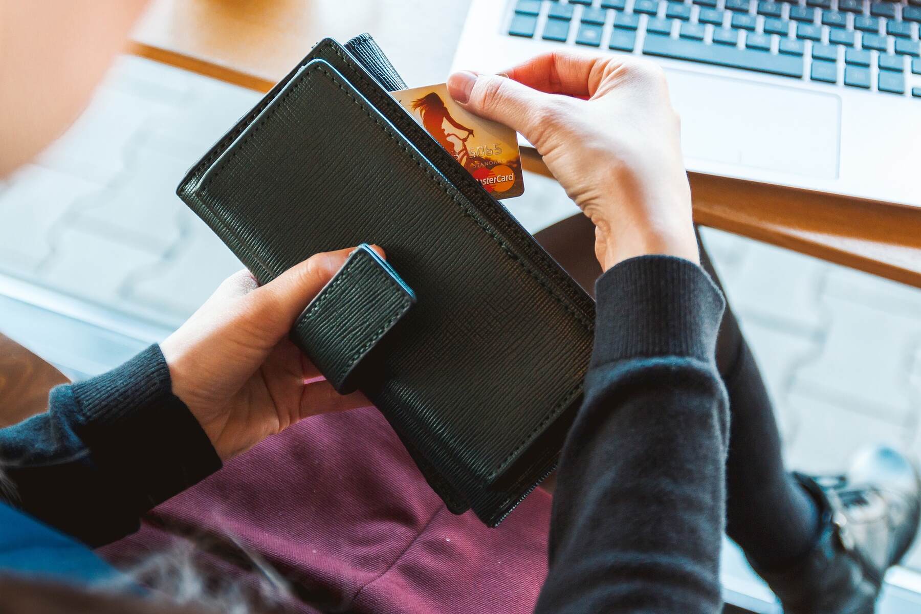 A woman holding a wallet and credit card