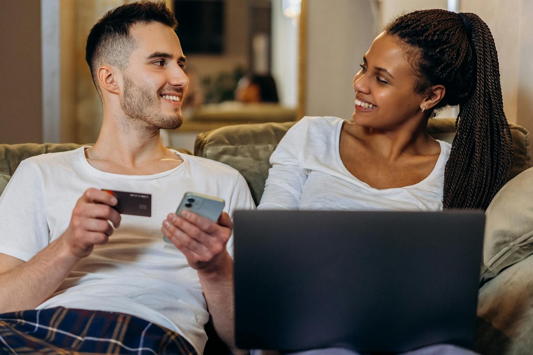 Couple shopping online with credit card and laptop at home