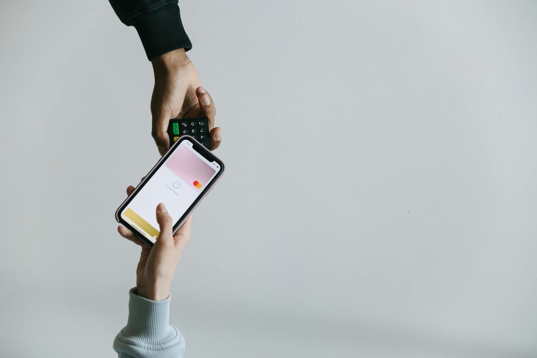 Woman using her smartphone to pay on a portable paying terminal