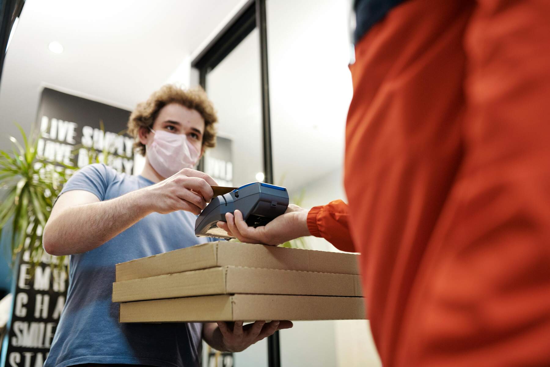 A man paying for his pizza delivery with his credit card