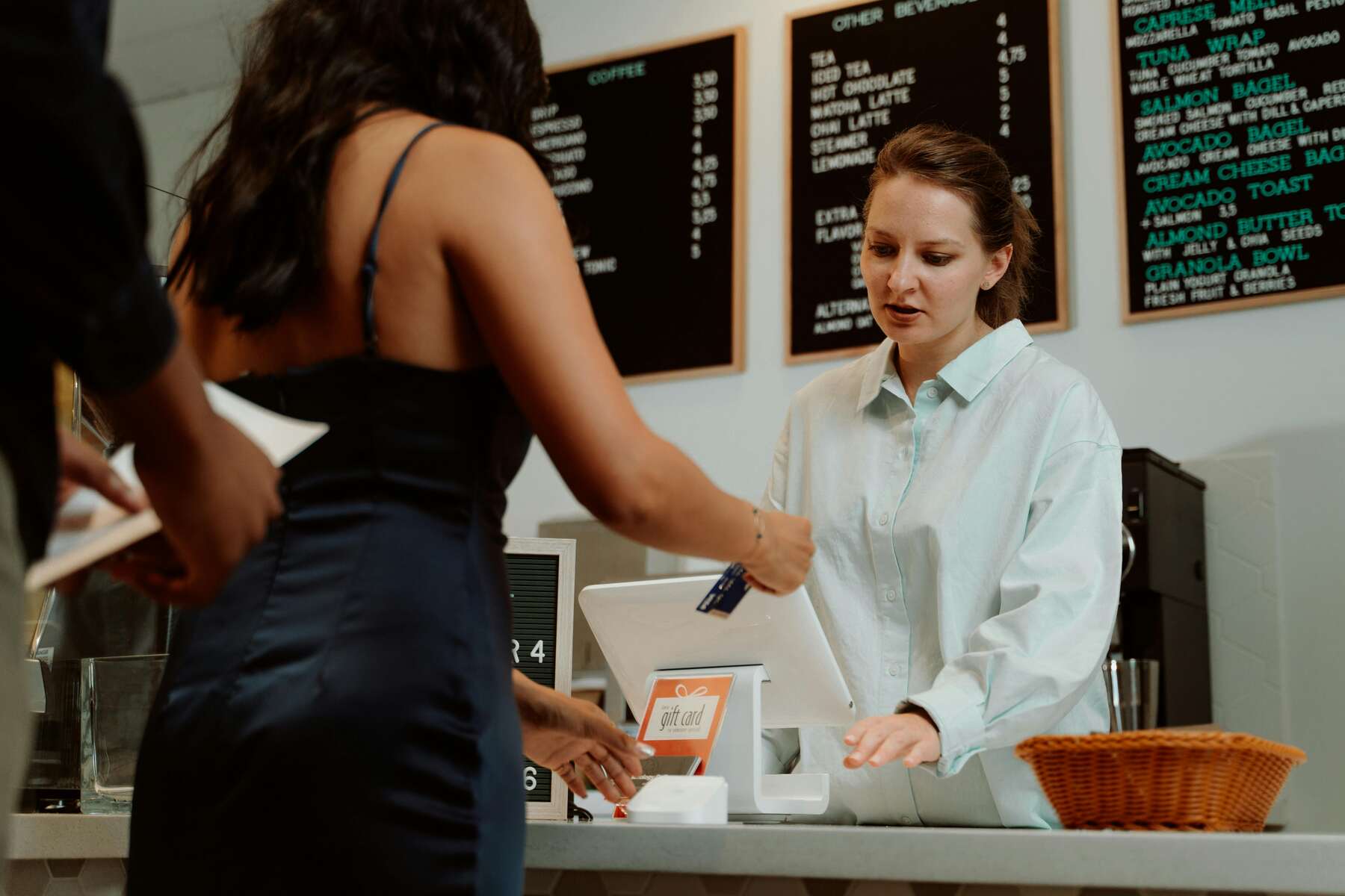 A woman paying on the cashier with her card
