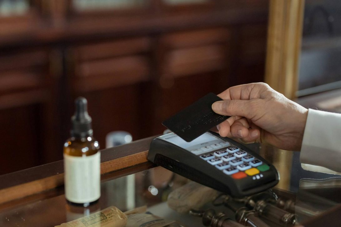 A man swiping his black card on the payment terminal