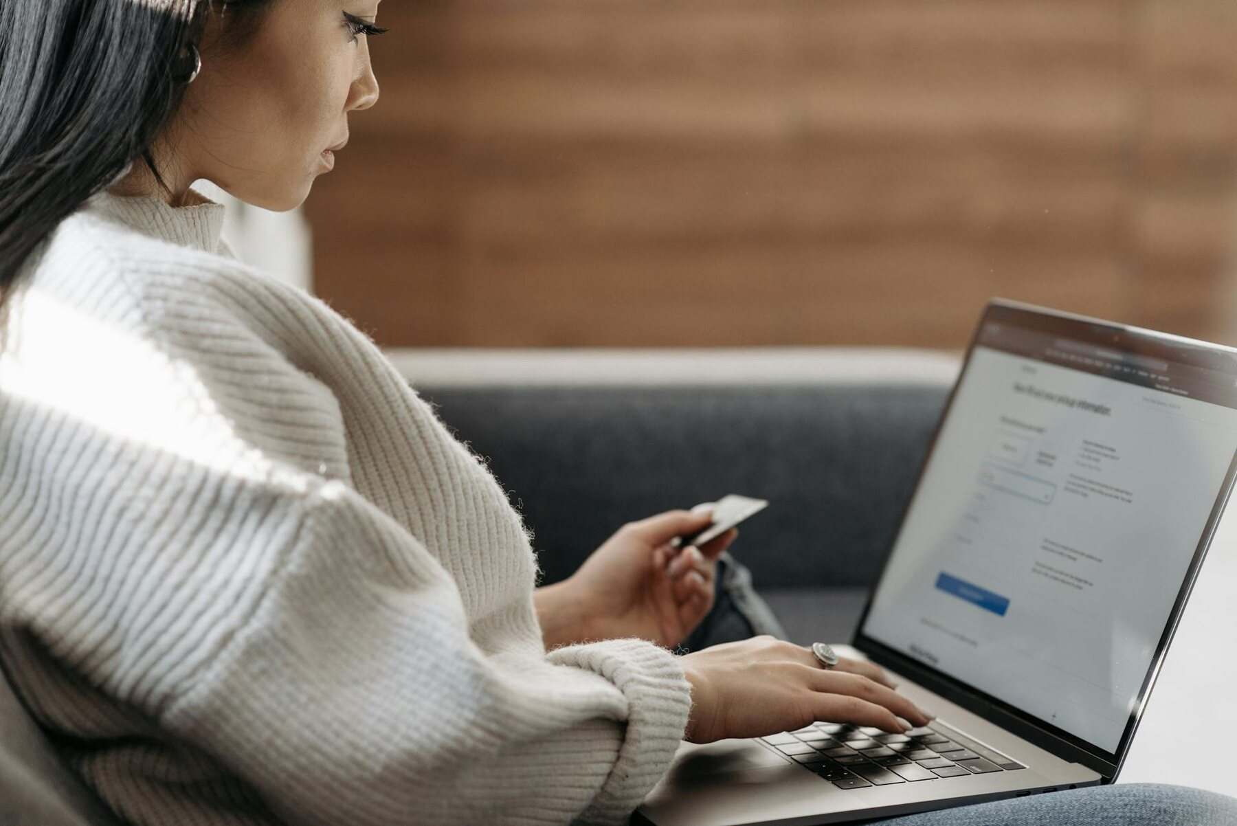 Woman using laptop while seated on couch