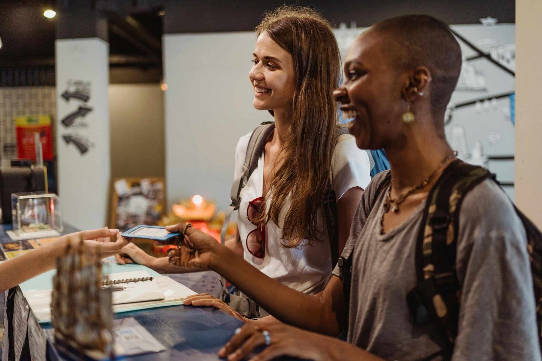 Two women smiling at the cashier while paying