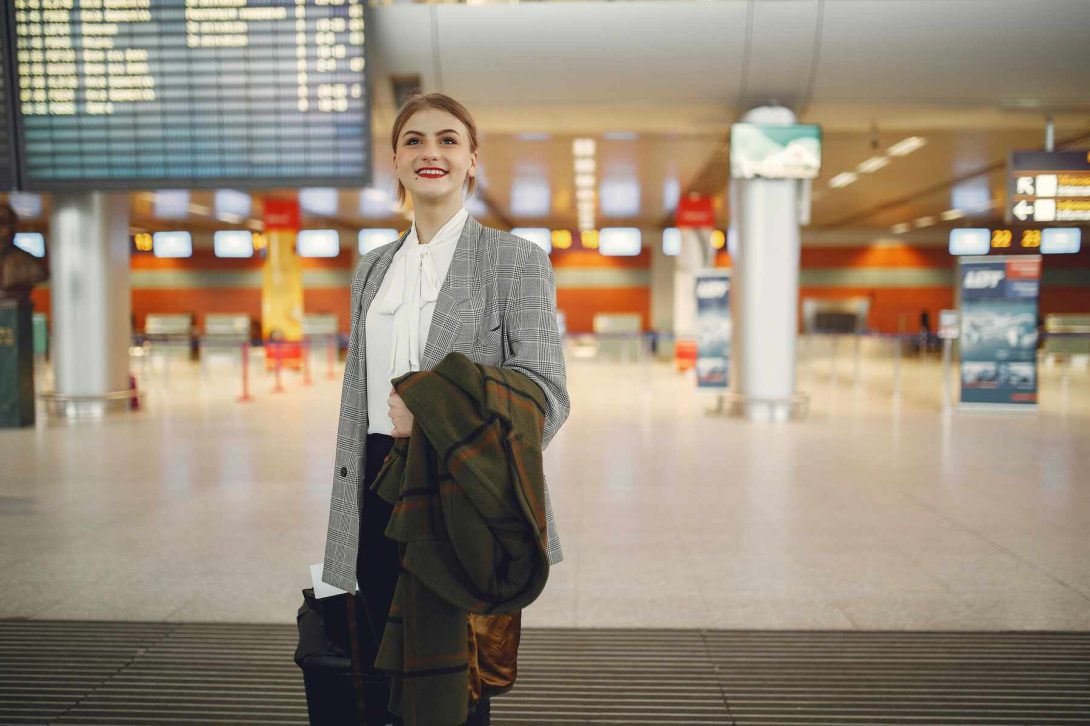 A woman in an airport holding her coat