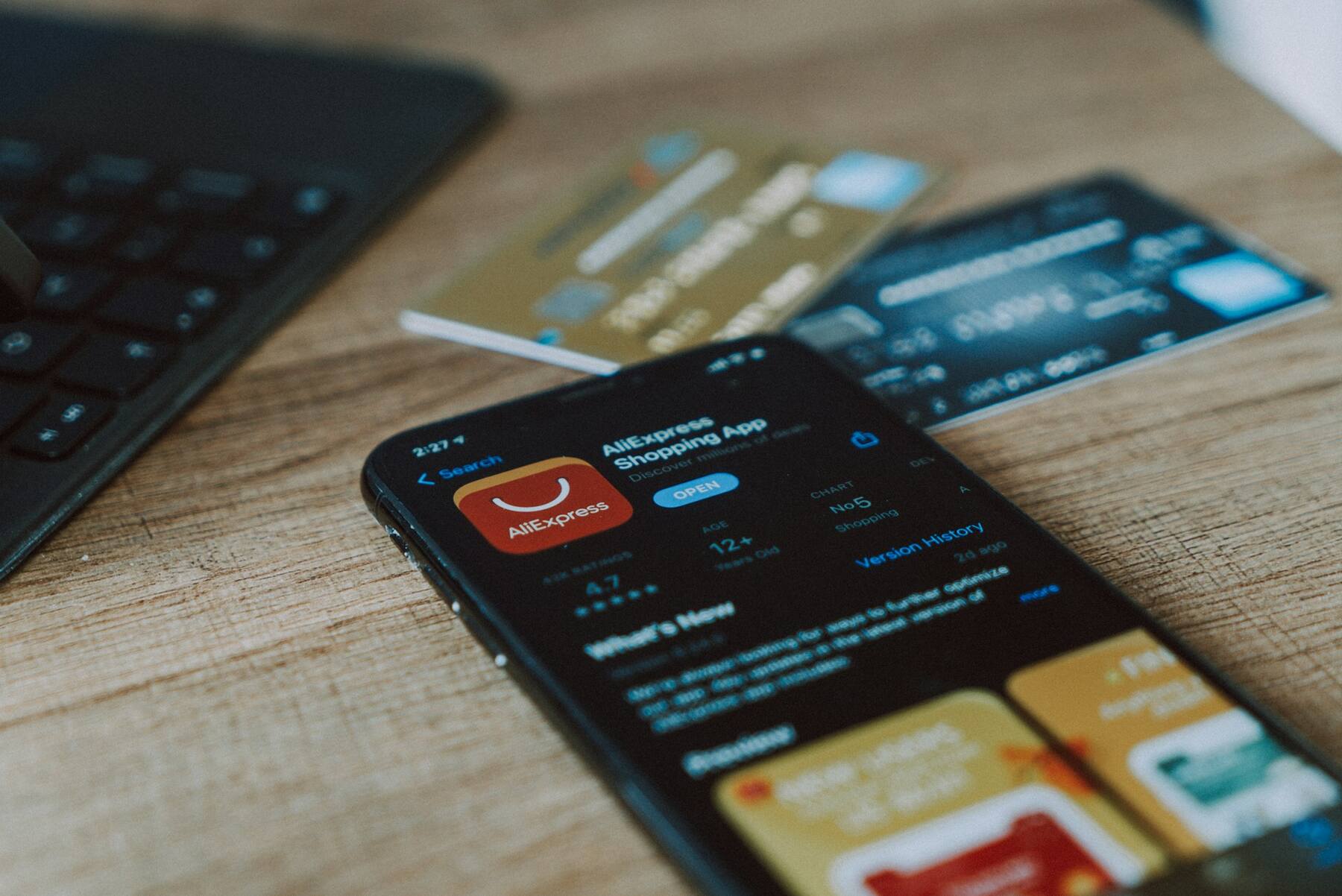 A mobile phone, laptop and two credit cards on a desk