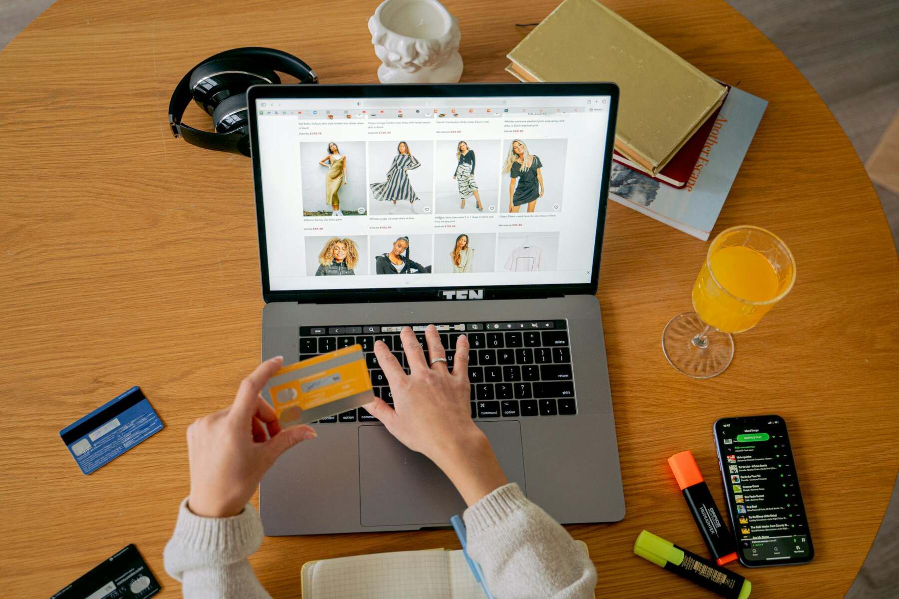 A woman typing on a laptop while holding a credit card