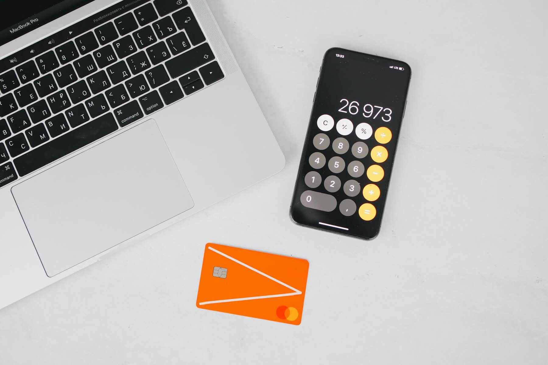 A credit card, mobile phone and a laptop on a desk