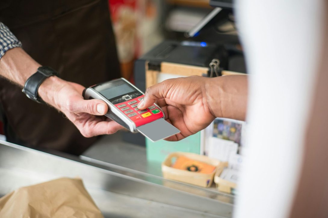 A cashier holding a terminal payment while the customer swipes his card