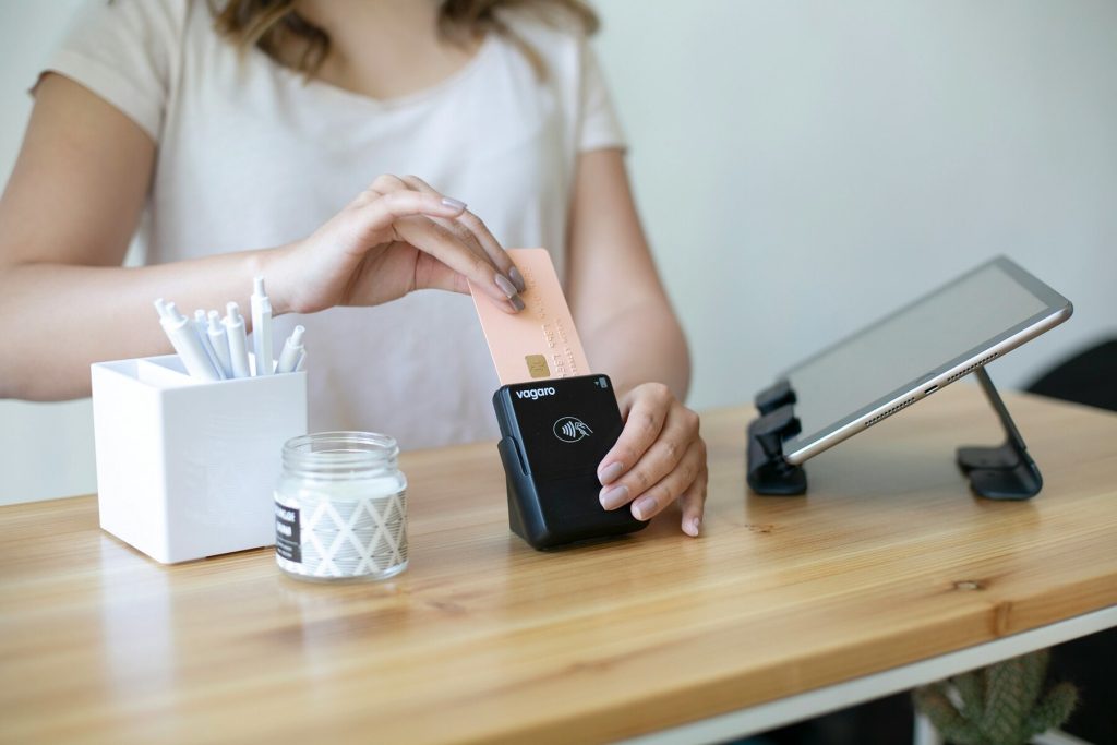 A woman swiping credit card on reader to make a payment